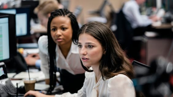 A group of women sitting at a desk

AI-generated content may be incorrect.